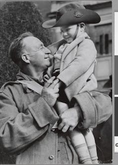 An Australian corporal reuniting with his son in Victoria in 1941 after an overseas deployment. 