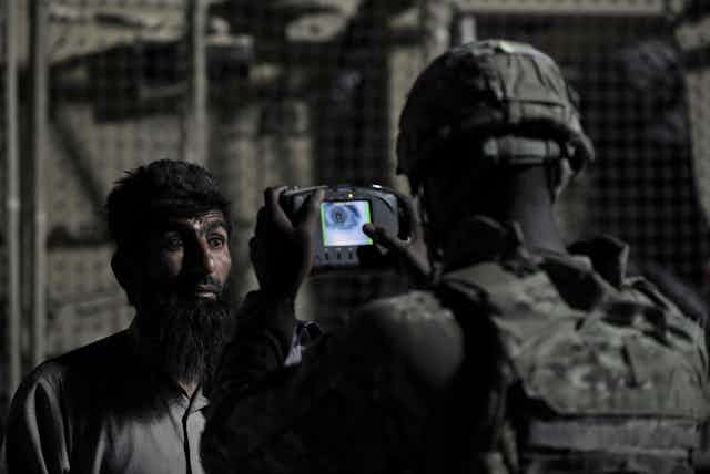 Un soldat américain scanne l'iris d'un civil afghan.