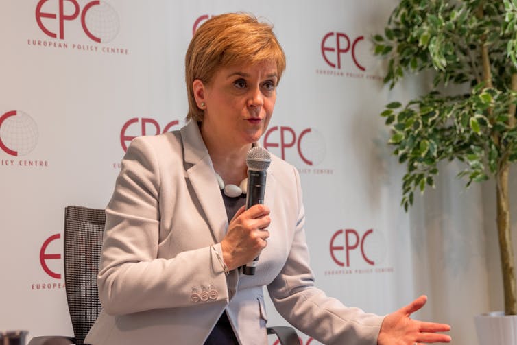 Scotland's first minister Nicola Sturgeon in a cream jacket holding a microphone.