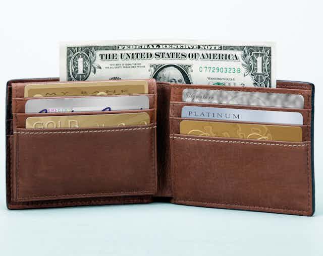 A brown wallet with various credit cards and a dollar bill sticking out the top