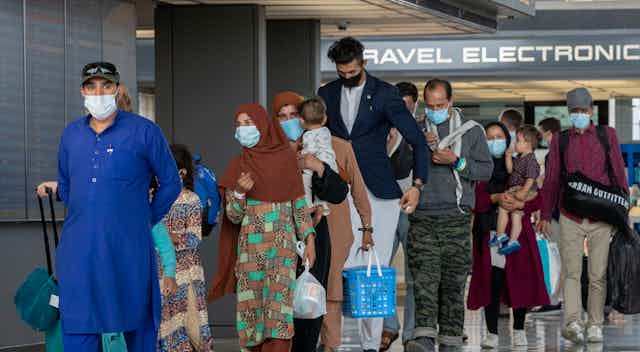 Refugees from Afghanistan walk through a U.S. airport.