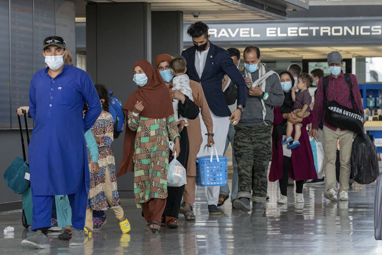 Refugees from Afghanistan walk through a U.S. airport.