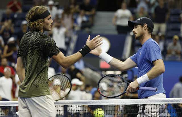 Stefanos Tsitsipas of Greece (L) and Andy Murray of Great Britain shake hands at the net.