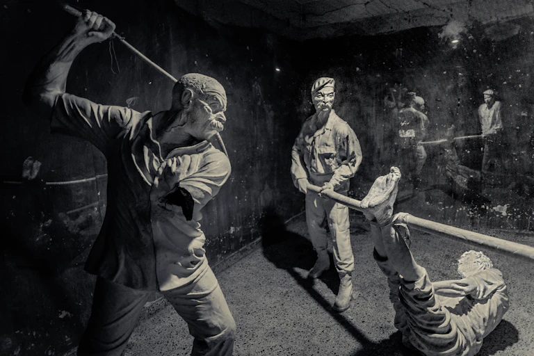 An image of a museum exhibit depicting people torturing a person