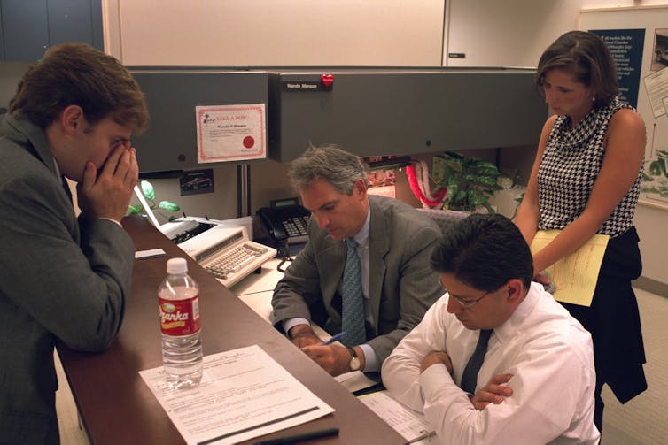 Four people working in an office together.