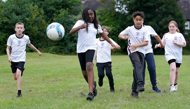 Boys play football on a green field