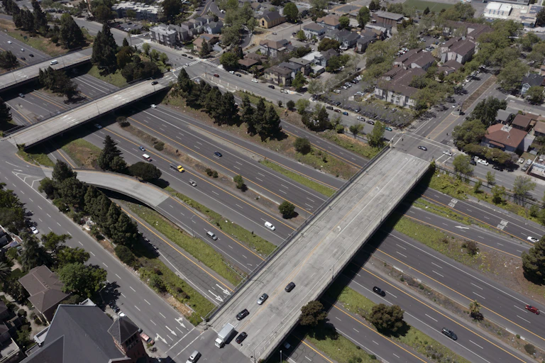 Highway with overpasses dividing neighborhoods.