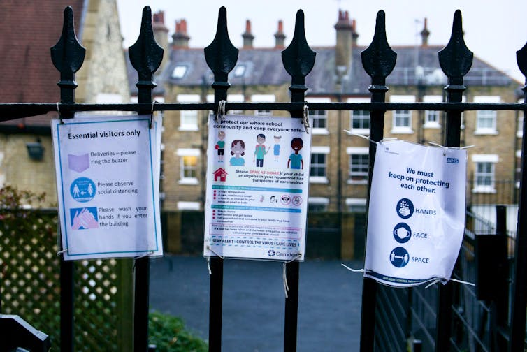 Posters about social distancing measures on the gates of a primary school in the UK