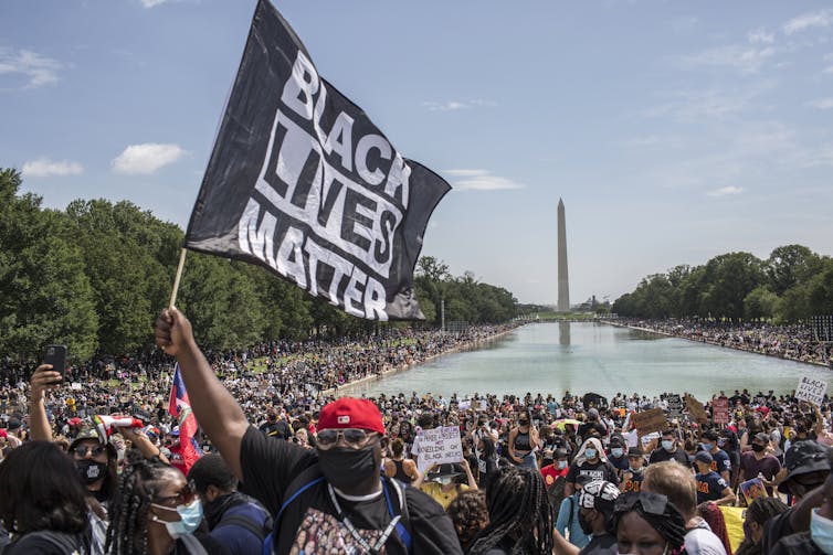 A demonstrator holds a flag with Black Lives Matter written on it at a protest at the Lincoln Memorial in Washington, D.C.