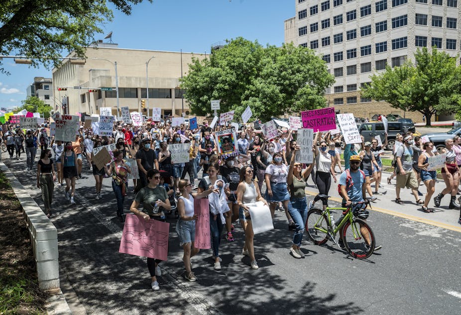 People protesting a Texas bill that outlaws abortions after a fetal heartbeat is detected march down a street to the state capitol in Austin on May 29.