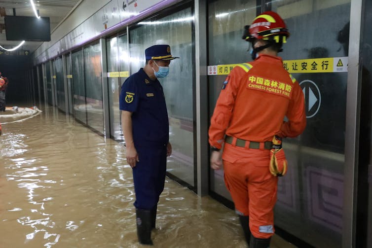 Firefighters pump rainwater from a flooded metro station in Zhengzhou, China