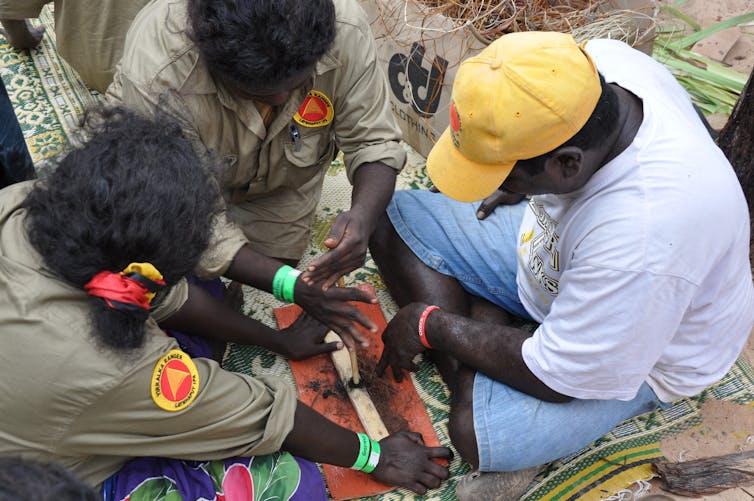 Dhimarru Indigenous Rangers teaching traditional fire making at Garma Festival.