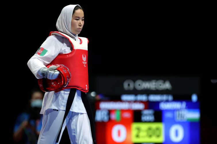 Afghan paralympian Zakia Khudadadi walks on to the mat with her helmet under her arm