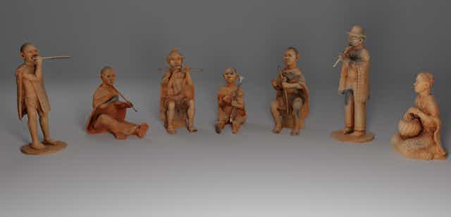 A row of seven clay figurines of people with musical instruments