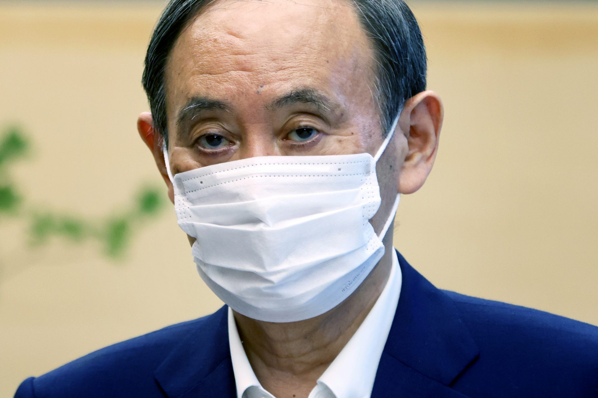 Head and sloulders picture of the Japanese prime minister, Yoshihide Suga, wearing a COVID mask.
