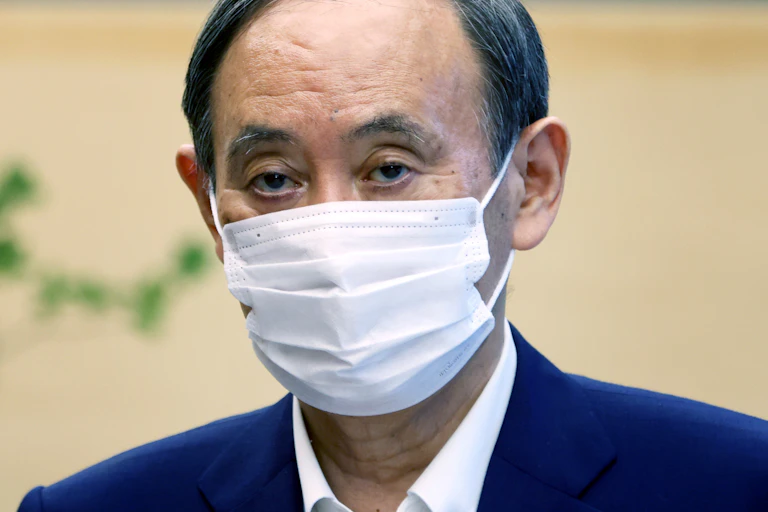 Head and sloulders picture of the Japanese prime minister, Yoshihide Suga, wearing a COVID mask.