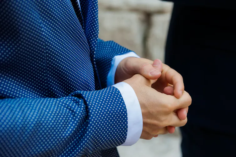 A man's hands twiddling his thumbs