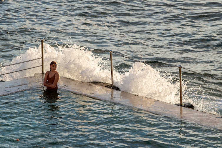 Woman sitting in an ocean pool.