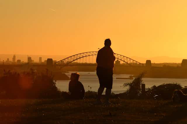 Person in front of Sydney Harbour Bridge at sunset