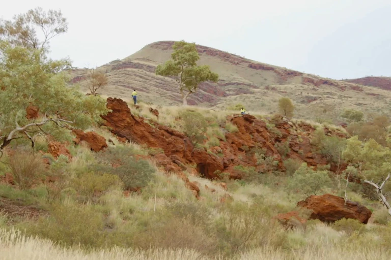 A person standing on top of the Juukan Gorge rock shelters.