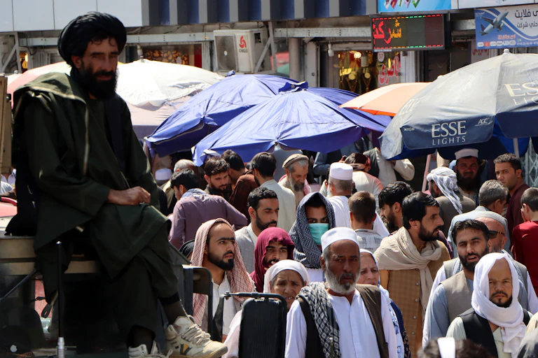 A Taliban fighter watches as people throng the streets of Kabul, September 2021.