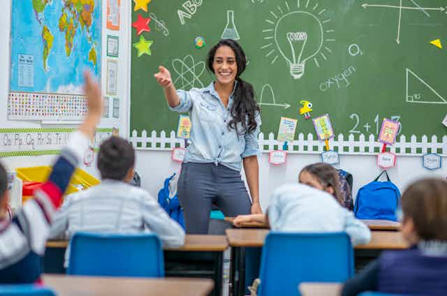 Teacher stands in front of classroom of  young students