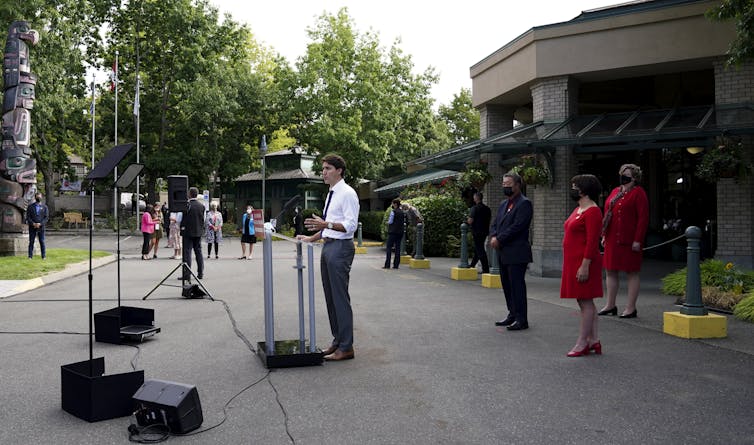 Liberal Leader Justin Trudeau standing at a microphone outside a building