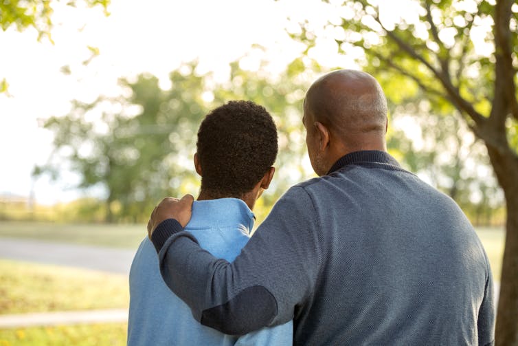 Father with his arm around his son.