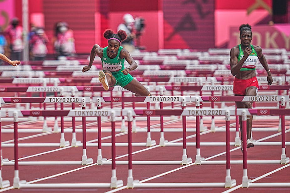 Two athletes jumping over hurdles during the Tokyo 2020 Olympics