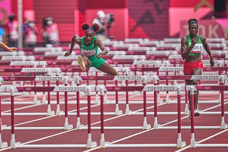 Two athletes jumping over hurdles during the Tokyo 2020 Olympics