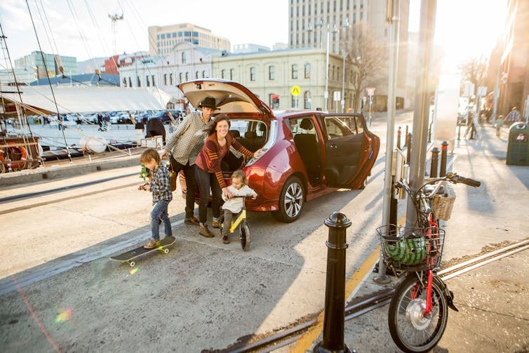 family unloads boot of electric car