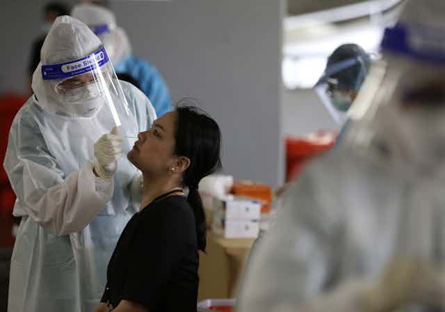 Person getting COVID-19 test from health worker in PPE