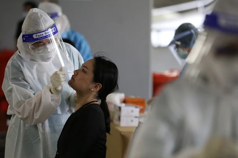 Person getting COVID-19 test from health worker in PPE