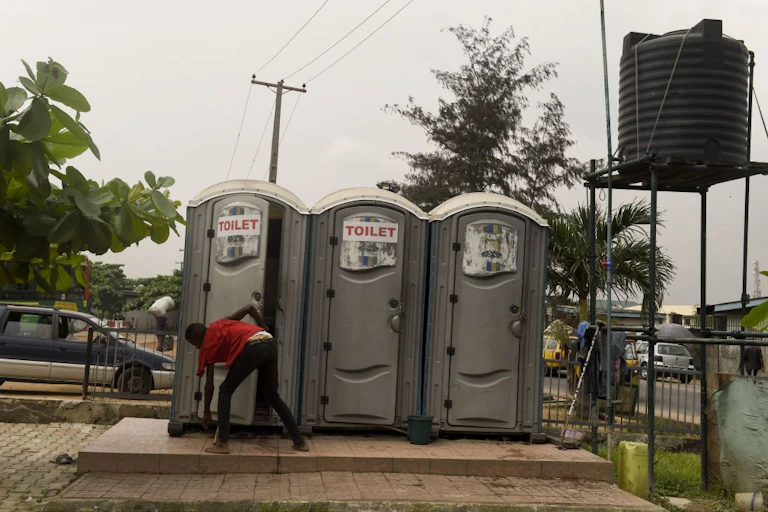 A boy outside portable toilets.