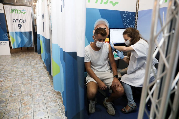 An Israeli man receiving his third vaccine dose