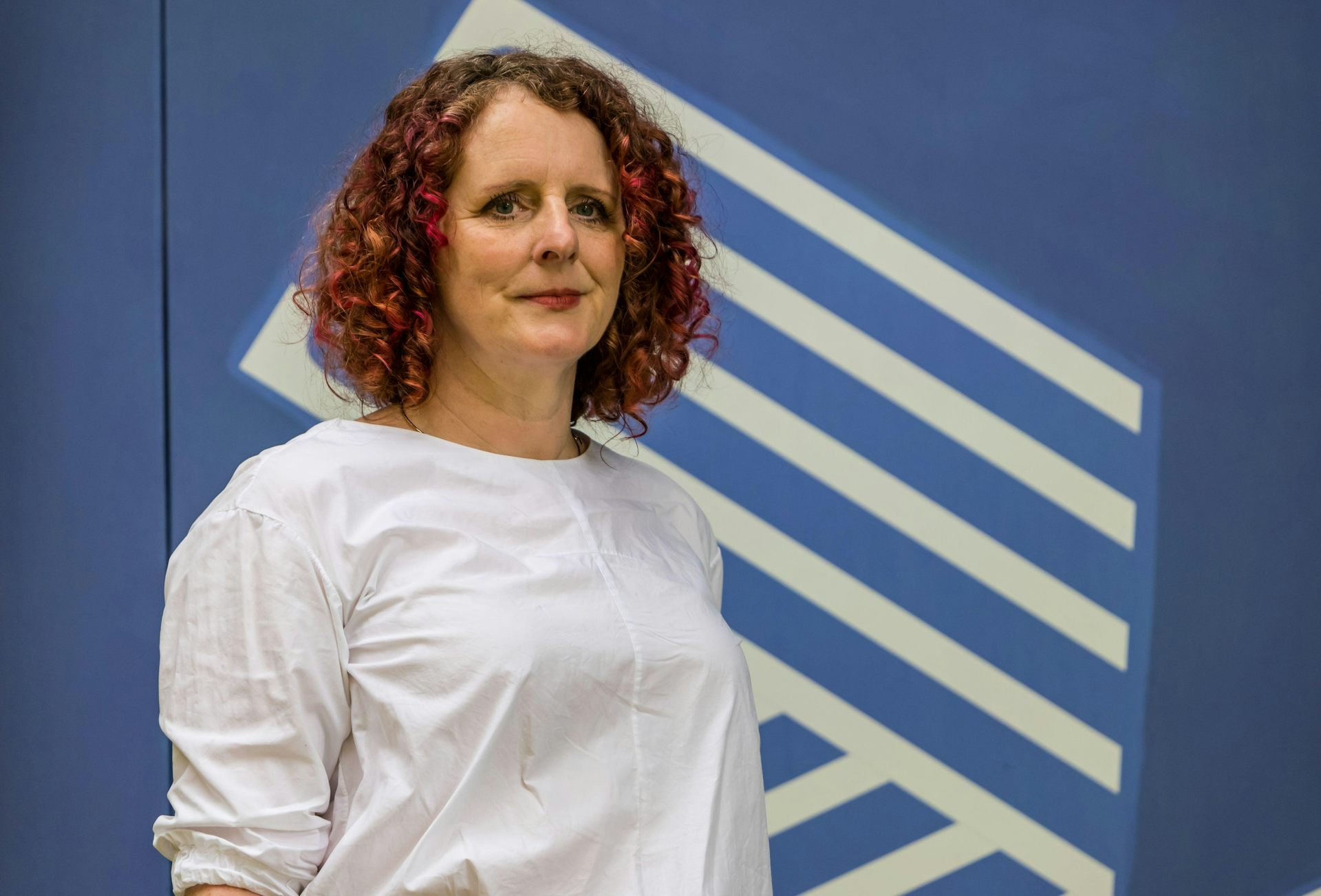 Maggie o'Farrell in white top against blue background.