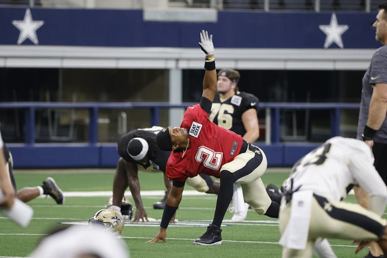 As U.s. Football Season Kicks Off, Climate Change Threatens The Game 42 A Football Player Stretches On The Field Surrounded By Teammates