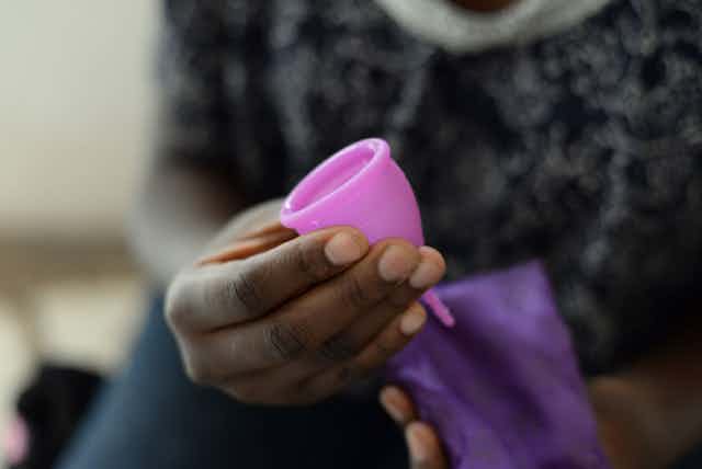 woman in Kenya holding a menstrual cup
