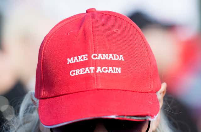 A woman wears a red hat that reads 'Make Canada Great Again'