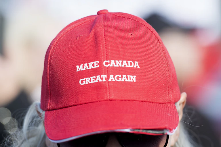 A woman wears a red hat that reads 'Make Canada Great Again'
