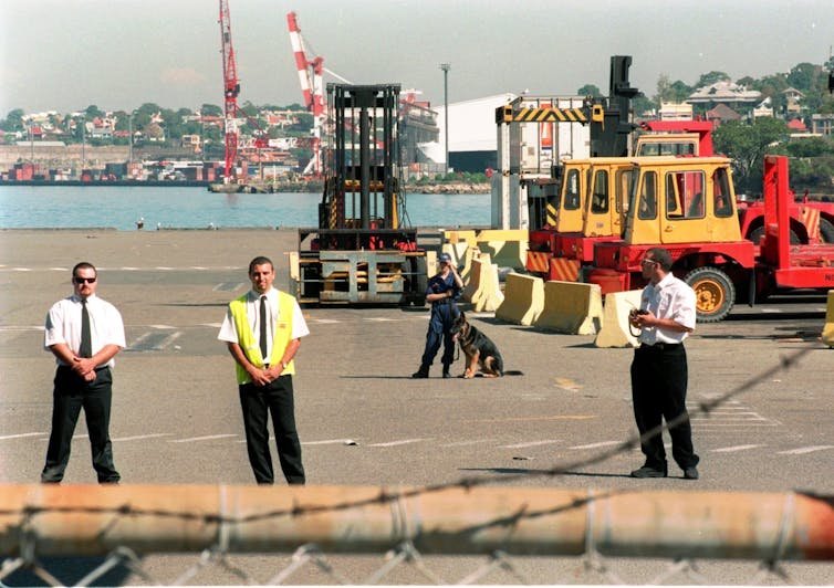 Private security guards and dogs keep watch at Patrick Corporation's dock at Sydney's Darling Harbour on April 8 1998, the day after the company fired all its 1,400 dock workers.