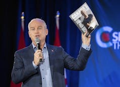 Conservative leader Erin O'Tool holding up a copy of the party's election platform