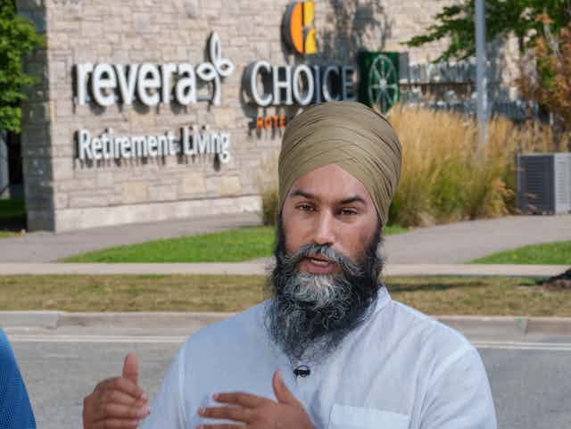 NDP leader Jagmeet Singh in front of the entrance to a retirement living facility