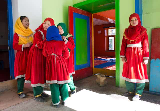 Schoolgirls in uniform gather in a colourful building in Afghanistan