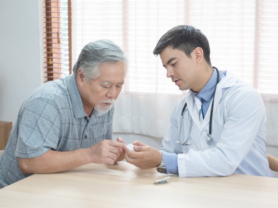 An older man speaking with his doctor about a prescription.