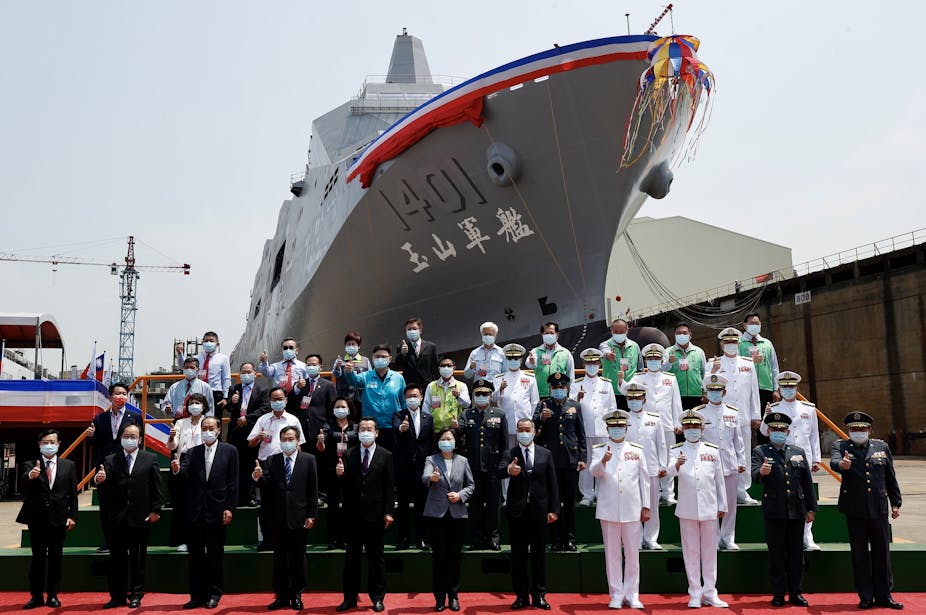 President Tsai Ing-wen with Taiwanese navy personnel and politicians in front of a new warship berthed at a new amphibious naval dock.