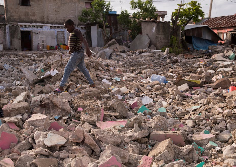 A boy walks through rubble in Haiti. 
