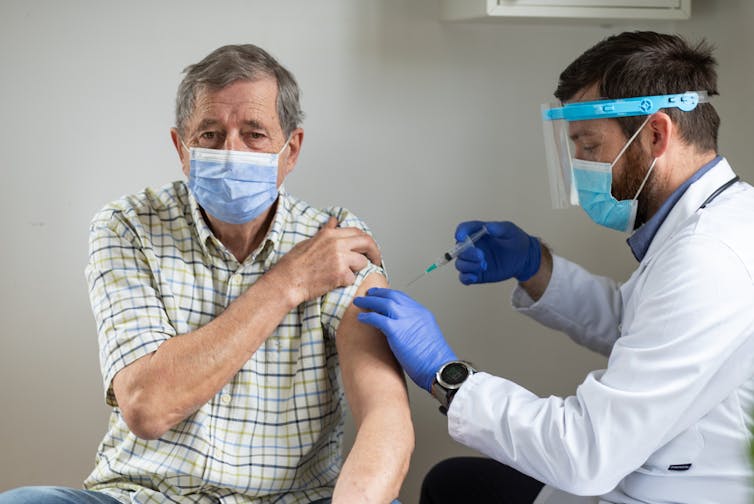 An elderly man being vaccinated against COVID-19