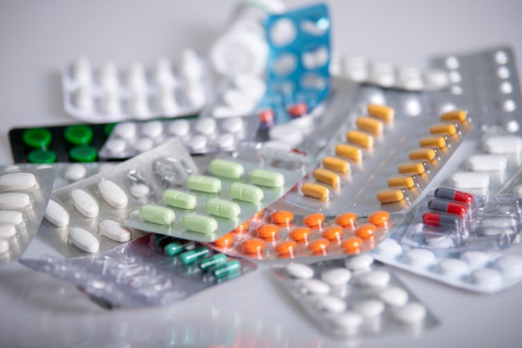 A table covered in blister packs of medication.