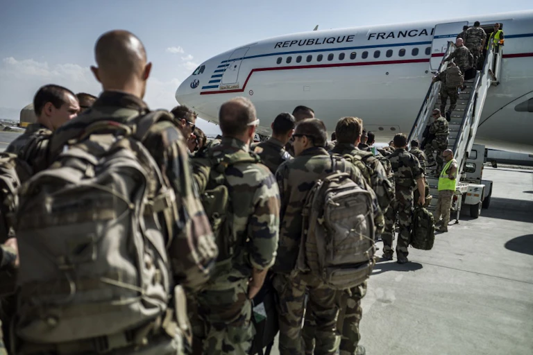 Soldats en treillis montent dans un avion de ligne siglé République Française